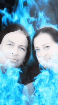 a man and a woman are surrounded by blue flames and smoke