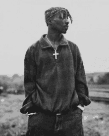 a black and white photo of a man with a cross necklace