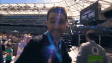 a man with a medal around his neck is standing in front of a crowd at a stadium with a sign that says super bowl