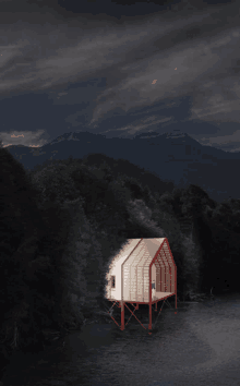 a house with a red roof sits in the middle of a dark forest