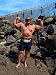 a shirtless man flexes his muscles while wearing sunglasses and a champion fanny pack