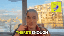 a woman says there 's enough in front of a yellow sign