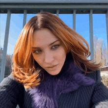 a woman with red hair and a purple fur coat