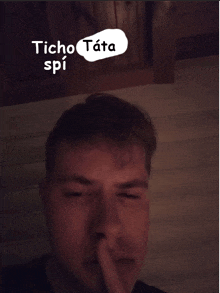 a man covering his mouth with his finger and a speech bubble that says ' tcho tata spi '