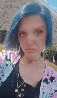 a woman with blue hair is wearing a choker necklace and earrings