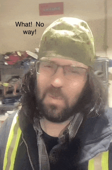 a man with a beard wearing glasses and a green hat says " what no way "