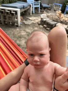 a baby without a shirt is being held by a person