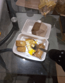 a styrofoam container filled with food and a spoon in it