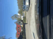 a row of houses with red roofs are lined up along a road