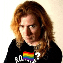 a man with long hair is wearing a black shirt with a rainbow flag and a question mark