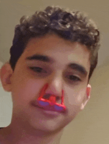 a young man with a red nose clip on his nose .