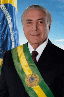 a man in a suit and tie with a sash that says ordem e progresso