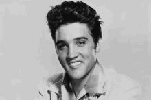 elvis presley is smiling in this black and white photo