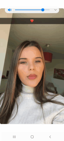 a woman in a white turtleneck takes a selfie