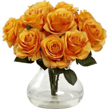 a clear glass vase filled with orange roses