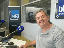 a man sitting in front of a france bleu banner