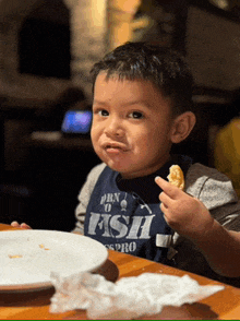 a boy wearing a shirt that says born to fish