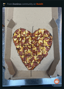 a heart shaped pizza in a box with the words from dominos community on reddit below it