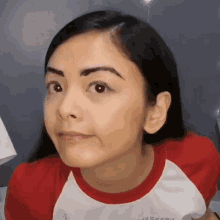 a close up of a woman 's face wearing a red and white shirt that says " believe us we are up "