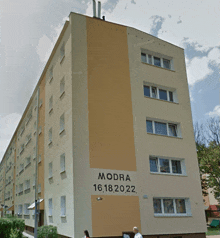 a building with a sign on the side that says modra 16.18.2022