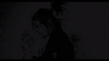 a man with a ponytail is praying in the dark