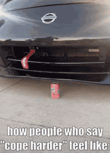 a nissan car with a can of gatorade on the ground under the bumper