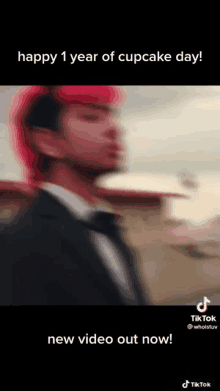 a blurry picture of a man in a suit and tie with red hair and the words `` happy 1 year of cupcake day ! ''