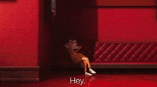 a cartoon character is sitting on a bench in a red room .