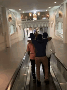 a group of people are walking on an escalator