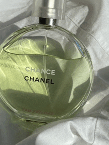 a bottle of chance chanel eau fraiche is sitting on a white cloth