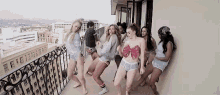 a group of women are dancing on a balcony in underwear .