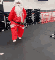 a man dressed as santa claus is walking through a gym