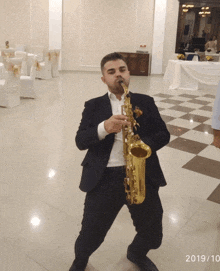 a man in a suit is playing a saxophone in a room with the date of october 10