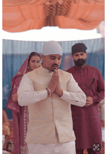 a man in a turban prays in front of a woman