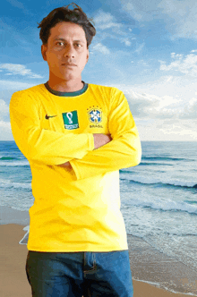 a man with his arms crossed wearing a yellow shirt that says brasil