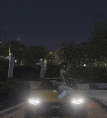 a woman sits on the hood of a yellow car with the letter w on it