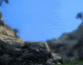 a blurry picture of a mountain with a blue sky