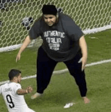 a man in a authentic italia shirt is standing next to a soccer player .