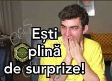 a man in a yellow shirt is covering his mouth with his hands and the words " esti plina de surprize " on the bottom