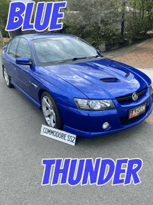 a blue commodore ssz thunder car is parked on the side of the road