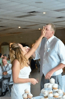 a bride and groom are feeding each other cupcakes