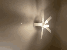 a white ceiling fan is hanging from the ceiling of a room