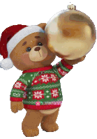 a teddy bear wearing a santa hat and sweater is holding up a christmas ornament