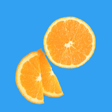 two slices of orange on a blue background one of which is cut in half