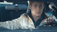 a man driving a car with a white jacket on