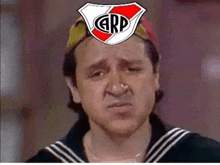 a man is wearing a sailor suit and a hat with a river plate logo on his head .