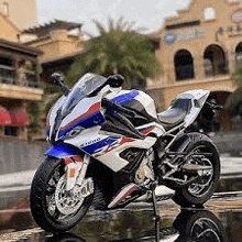 a blue , white and red motorcycle is parked on the side of a building .