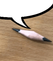 a broken pencil on a wooden table with a speech bubble above it