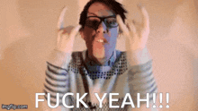 a man wearing glasses and a sweater is giving the middle finger and saying fuck yeah