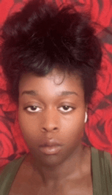 a close up of a woman 's face against a red background with roses